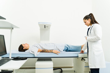 Sick woman getting a densitometry scan test at the imaging diagnostic center - obrazy, fototapety, plakaty
