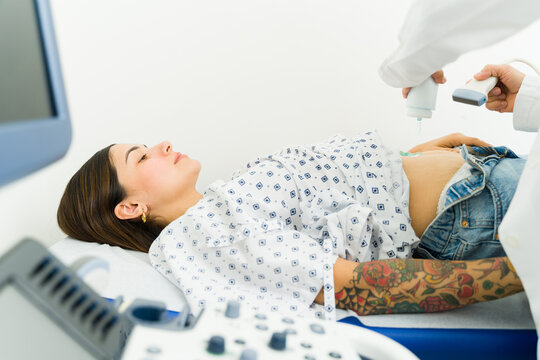 Pregnant latin woman getting an ultrasound to check the health of the baby