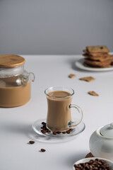 a cup of coffee with milk on a light background, a light breakfast for children, healthy and healthy food, coffee and dry biscuits, bran cracker, top view with copy space 
