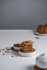 cracker with cereals and bran, diet cookies, delicious breakfast and healthy food, sugar-free dry biscuits, coffee with milk, dill cracker, on a light background, space for text 