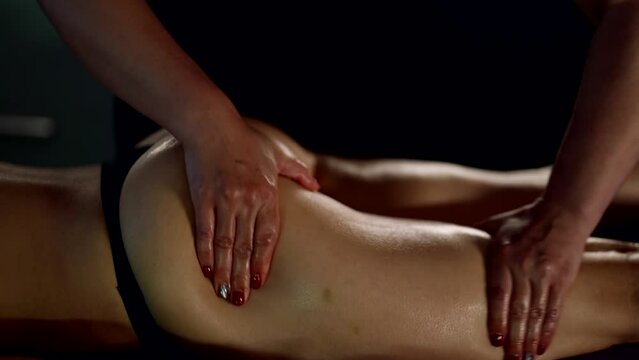 skilled professional masseuse is massaging female hips and buttocks for anti-cellulite effect