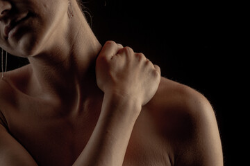Obraz premium female back on a dark background, hands on the neck with cervical osteochondrosis