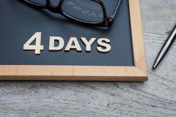 4 days work week concept with 4 DAYS words and eyeglasses on the black chalkboard