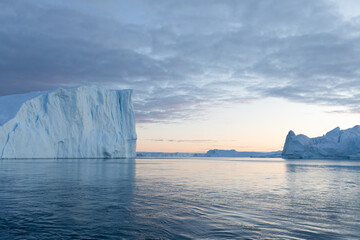Climate change and global warming. Icebergs from a melting glacier in Greenland. The icy landscape...