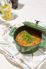 Composition with vegetable soup in ceramic pot. Minestrone soup with vegetables on summer day. Minestrone soup. Vegan menu. Hot dishes. Vegetables food. Eat less meat.