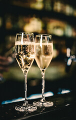 Two glasses of cold dry white champagne wine on bar