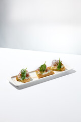 Aesthetic composition with tomato bruschetta on white background with harsh shadows. Italian bruschetta with tomatoes and cheese on fine dining in summer. Elegant menu concept.