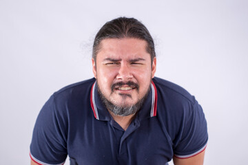A guy in his late 30s squinting and straining his eyes in an attempt to focus clearly at something. Deteriorating eyesight and blurry vision. Isolated on a white backdrop.