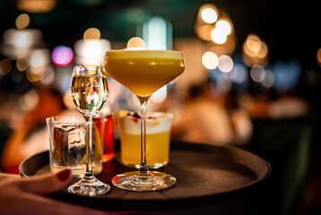 glasses alcohol cocktail set on a waiter tray in bar