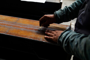 Close up hands of engineer on steel bar taking measurements