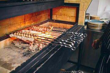 Shish kebab on skewers from different types of meat is fried on the grill