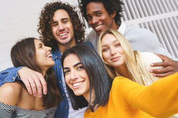 Obraz premium Company of multiethnic friends taking selfie