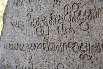 Inscriptions of tamil text on the walls of historical ancient temple in Tamilnadu. Ancient tamil inscriptions carved in the exterior temple walls. Stone wall texture.