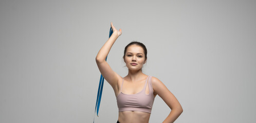 Brunette woman with a measurement tape. Athletic slim woman measuring her body by measure tape after a diet. Concept of healthy eating and dieting.