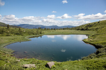 The bowl of a mountain lake surrounded by forests and peaks