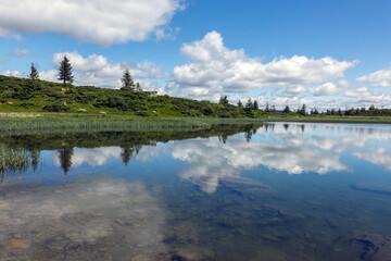 Fototapeta premium Reflection of the blue sky in the water surface of a mountain lake