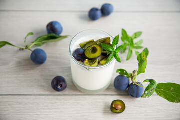 sweet homemade yogurt with fresh plum slices in a glass