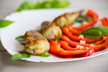 Pieces of fried hake fish in a plate with pepper