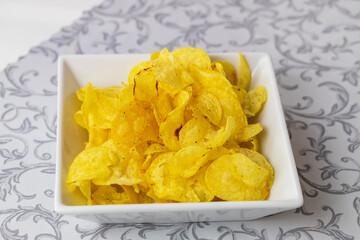 Potato chips sprinkled on a white plate.