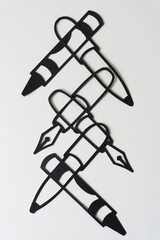 overlapping paper silhouettes of writing instruments (crayons, fountain pen, and ball point)