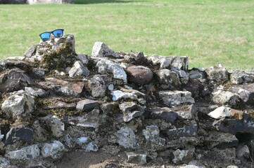 Forgotten sunglasses on a medieval stone wall.