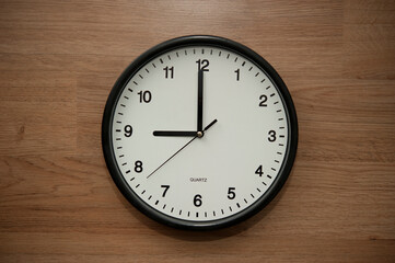 office wall clock indicating the nine o clock hour