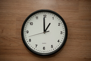 office wall clock indicating the one o clock hour
