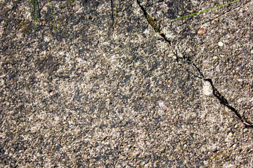 Old cracked stone.Authentic stone hard grunge texture.Natural stone background with crack and ancient grass.