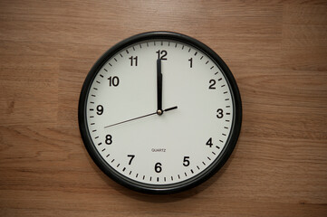 office wall clock indicating the twelve o clock hour