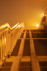 Stairs on a foggy street at night. Outdoors stairs against a foggy night sky