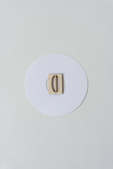white paper ring and the letter o in wooden stencil type on blank paper