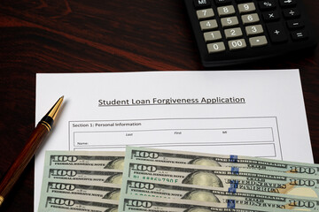 Student loan forgiveness application with cash money. Student debt crisis, tuition assistance and...