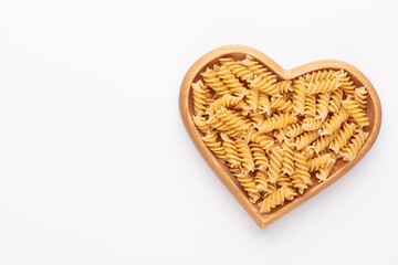 Pasta in a heart shaped wood bowl.