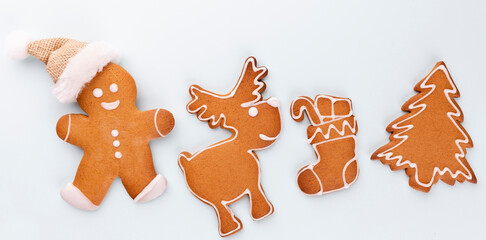 Gingerbread man, cookies and Christmas decor on pastel background.