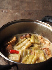 braised bitter gourd with tofu, tomato, chili and pork bone in saucepan
