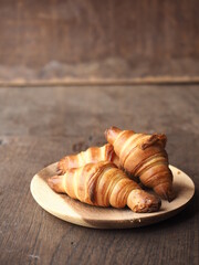 French butter croissants on wooden plate