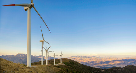 Fototapeta na wymiar Beautiful wind turbine in the countryside in the time of sunset background. Wind Turbines Windmill Power Farm. Carratraca on the outskirts of Malaga, Spain.