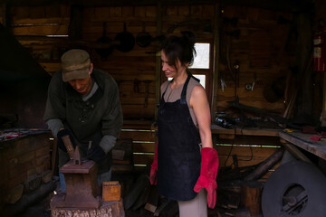 Obraz na płótnie Canvas Woman in blacksmith shop. Interior of an old forge.