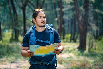 Naklejka premium Hikers reading a map while trekking in nature. Nature. Lifestyle. People and leisure time concept. Men hikers are looking for destinations on the map.