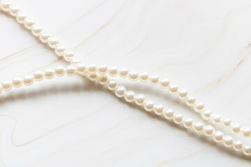 Pearl necklace on a marble background with copy space.
