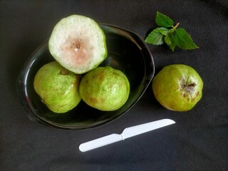 Guava fruit and knife on black background 