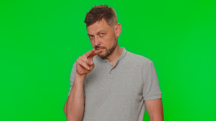 I am watching you. Bearded handsome young man pointing at his eyes and camera, show I am watching you gesture, spying on someone. Adult guy isolated alone on chroma key studio background indoors