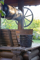 rural wooden well and black bucket of water