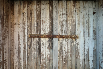 An old grungy wooden door with paint peeling off.