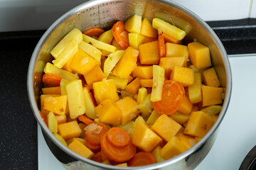 Vegetables for pumpkin soup are fried and languished in a saucepan