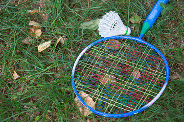 badminton racket and shuttlecock on grass