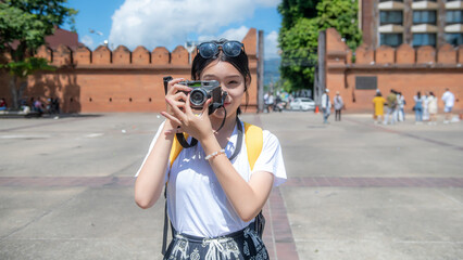 Asian woman traveling with a backpack travels to Tha Phae Gate in the old city of Chiang Mai in Chiang Mai, Thailand.
