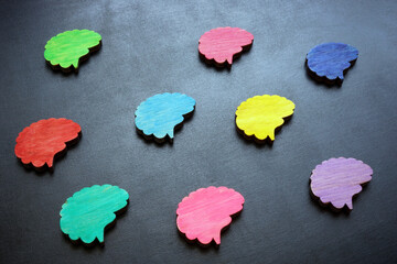 Neurodiversity concept. Multi-colored figures of the brain on a dark surface.