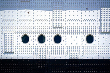 Historic ship's side with rivets and porthole