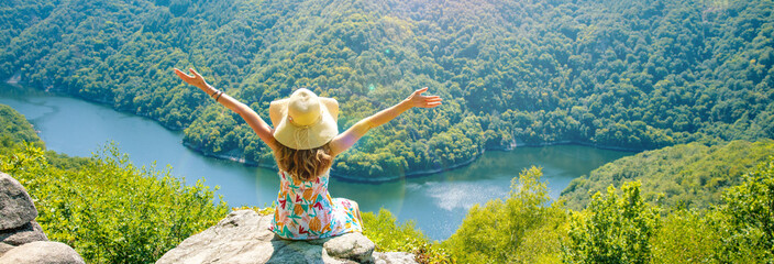 woman sitting on the mountain peak and amazing view of dordogne river and forest